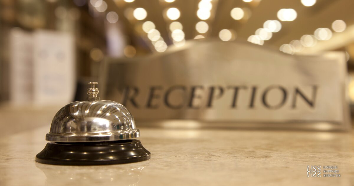 Polished bronze hotel reception bell and signage